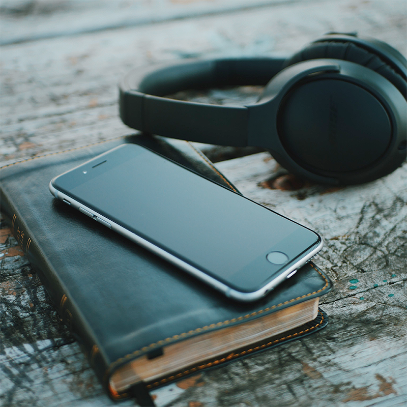 Bible with smartphone and headphones